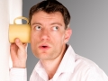 Man listening through the wall with the cup